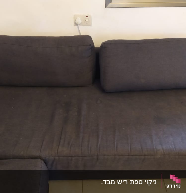 ספה כהה עם כתמים על המושב והכריות
